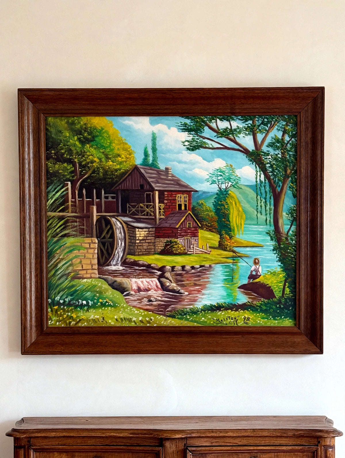 Styled lifestyle photo — the Melitón Rodríguez 1998 watermill oil shown hanging above an antique sideboard in a vintage living room (display inspiration)