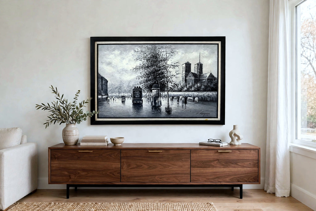 Styled lifestyle photo — the Paris Notre-Dame street scene oil hanging at true scale above a modern walnut credenza in a bright living room (styled display inspiration)