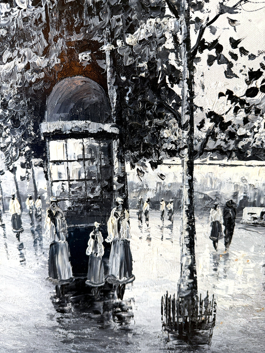Detail — the advertising column, tree and strollers reflected in the wet pavement in the Paris Notre-Dame street scene