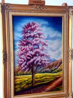 1985 signed oil on canvas pink flowering tree landscape, framed — front view on an easel