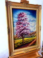 1985 signed oil on canvas pink flowering tree landscape, framed — front view from a right angle
