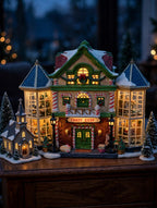 Styled display inspiration: the Child's Wonder Candy Shop lit at dusk on a sideboard beside a miniature village church and snow-dusted pine trees