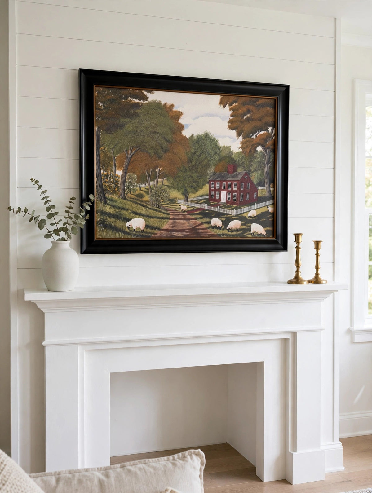 Styled lifestyle photo — the framed Sheep Farm print above a white fireplace mantel in a bright country living room (display inspiration)