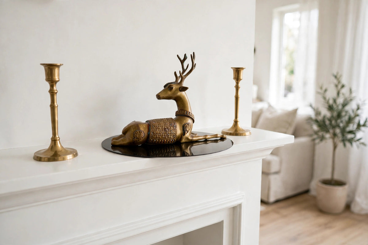 Styled lifestyle photo — the brass reclining stag figurine on a white fireplace mantel in a bright living room (display inspiration)