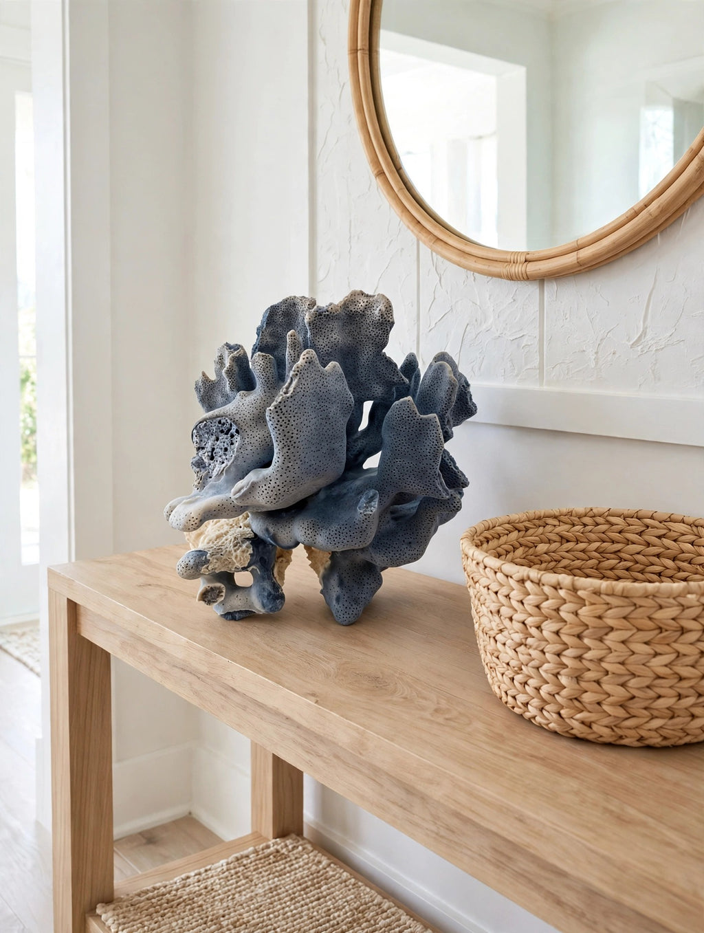 Styled lifestyle photo — the blue coral specimen on a light wood console table in a bright entryway (display inspiration)