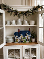 Styled lifestyle photo — Brownlow House on a china hutch shelf with plates and Christmas garland (display inspiration)