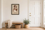 Styled lifestyle photo — the framed Princess Diana memorial print above a cushioned bench in a bright entryway (display inspiration)