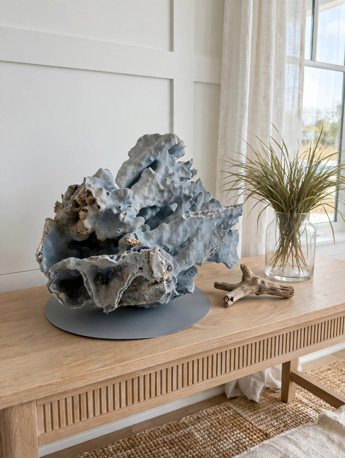 Large natural blue coral specimen on a coastal console table with driftwood and a glass vase (styled display inspiration)