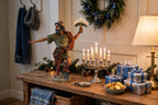 Judah Maccabee displayed on an entryway console with a lit menorah and gifts - display inspiration