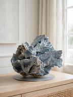 Large natural blue coral specimen on a console table in a bright coastal room — styled display inspiration