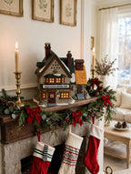 Giggelswick Mutton & Ham in a styled fireplace mantel Christmas display with garland, candlesticks and stockings (display inspiration; only the building is included)