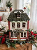 Department 56 M. Fezziwig Warehouse, Dickens' Village, 1986 – shown on a bright Christmas mantel with garland and pine cones (styled display inspiration)