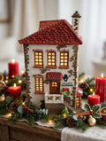 Department 56 Dickens' Village C. H. Watt Physician #5568-9 — styled scene: lit on a Christmas mantel with garland and red candles (display inspiration)
