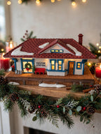 Department 56 New England Village Weston Train Station #5931-5 — styled scene: lit on a Christmas mantel with garland and red candles (display inspiration)