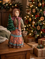 Babouska displayed on a side table beside a lit Christmas tree with gifts (styled display inspiration)