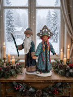 Grandfather Frost & Snowmaiden displayed on a console by a snowy winter window with candles and greenery - display inspiration