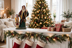 Styled lifestyle photo — on a white Christmas mantel with a lighted evergreen garland, red stockings and wrapped gifts, a lit Christmas tree behind (display inspiration)