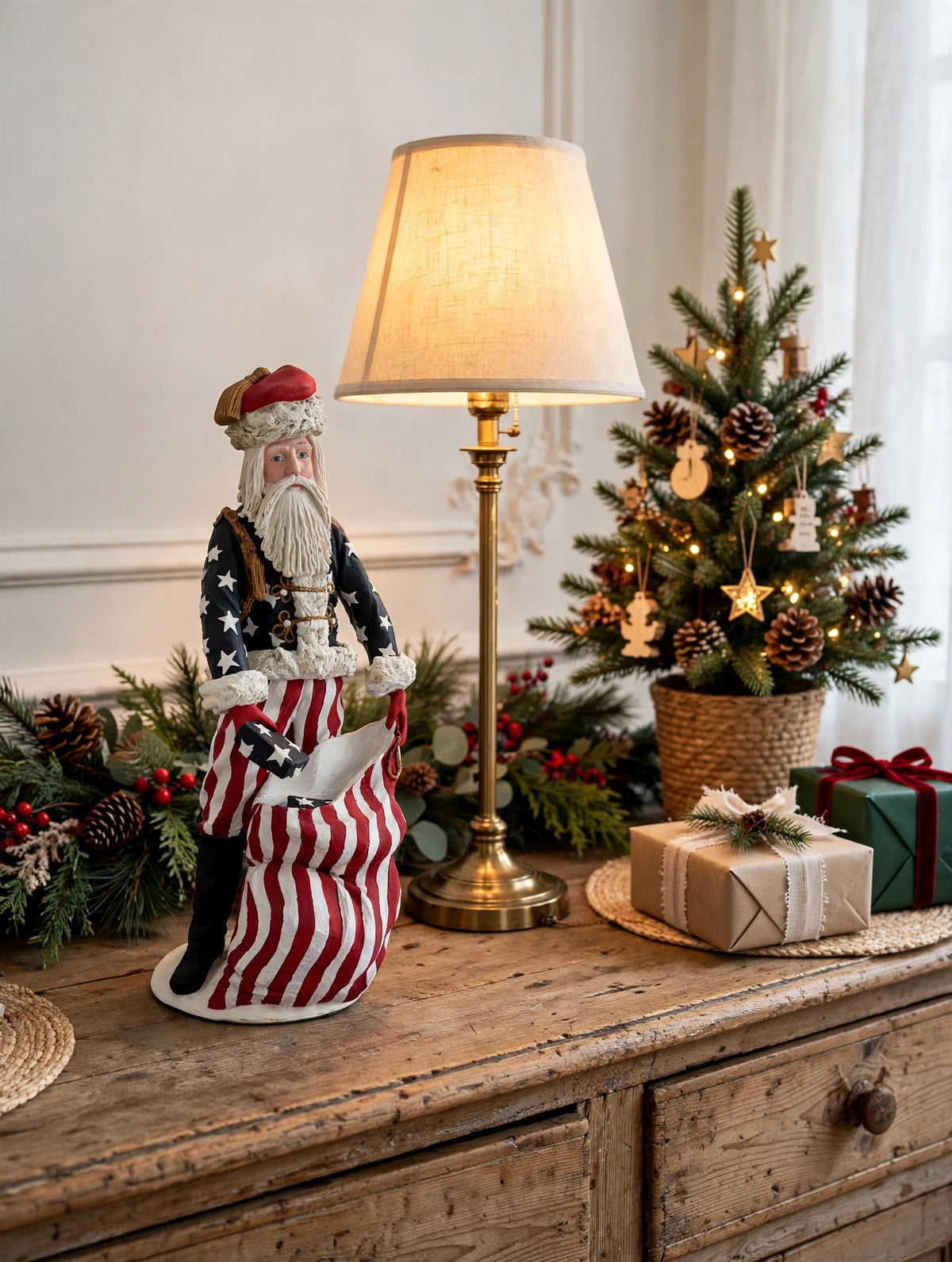 Styled lifestyle photo — on a vintage wooden sideboard beside a tall table lamp, with a tabletop Christmas tree, garland and wrapped gifts (display inspiration)