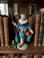 Styled lifestyle photo — display inspiration: Sir Christmas figurine on a library shelf among leather-bound books