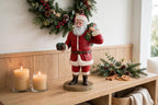 Styled lifestyle photo — display inspiration: Santa's Gift figurine on an entryway console with a wreath and candles