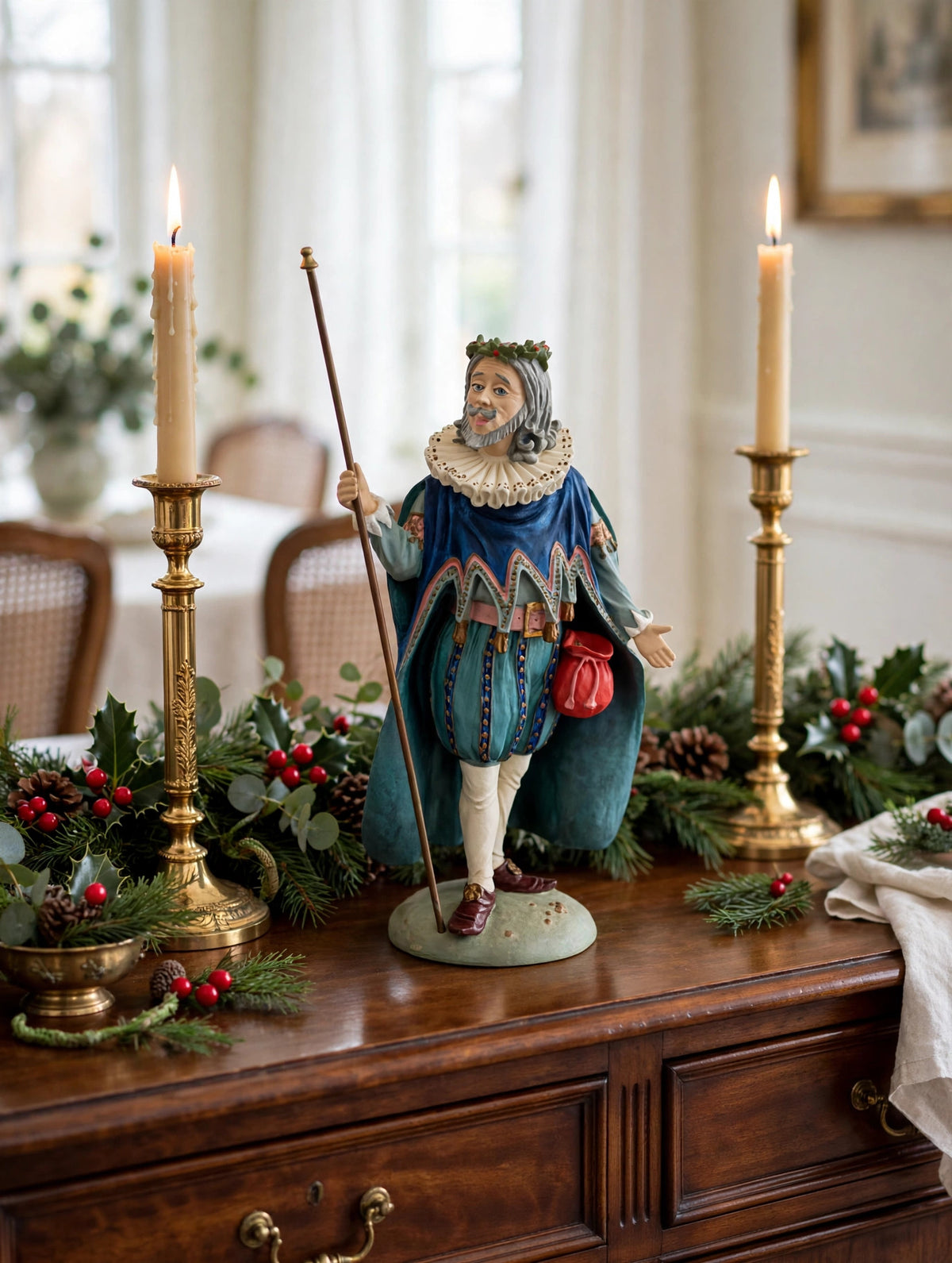 Styled lifestyle photo — display inspiration: Sir Christmas figurine on a sideboard with gold candlesticks and Christmas greenery