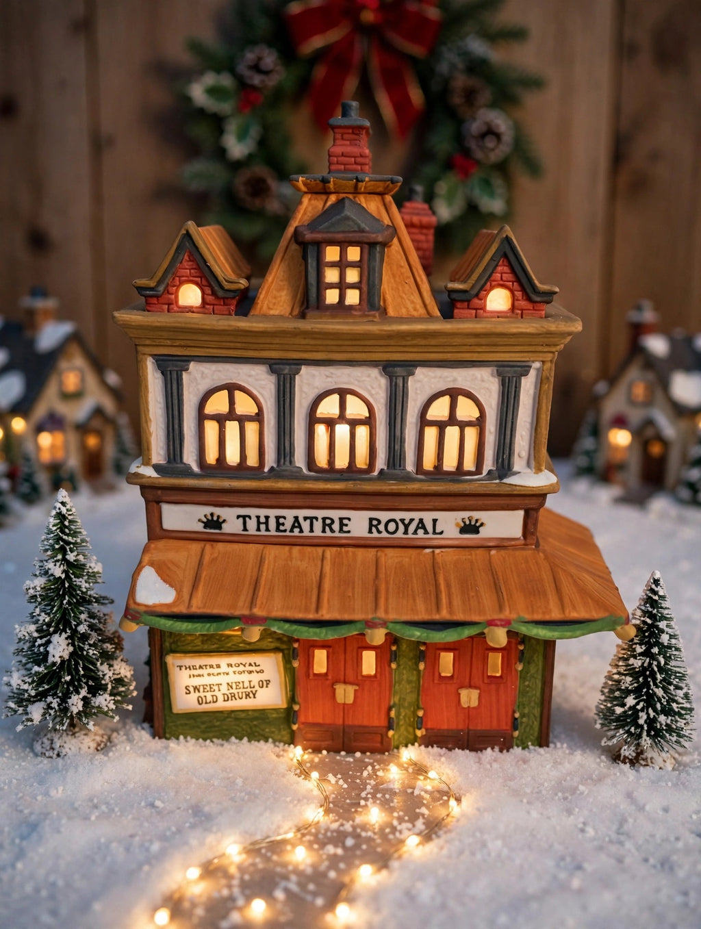 Styled lifestyle photo — Theatre Royal as the centerpiece of a tabletop Christmas village display with bottle-brush trees (display inspiration)