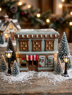 Ceramic Christmas village Toy and Doll shop in a tabletop village scene with lamp posts (styled display image for inspiration; the ceramic shop is the item for sale)