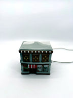 Ceramic Christmas village Toy and Doll shop, front view from above showing the snow-covered roof
