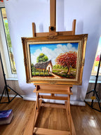 1984 signed oil on canvas tropical cottage landscape, framed — front view on an easel, wide studio shot
