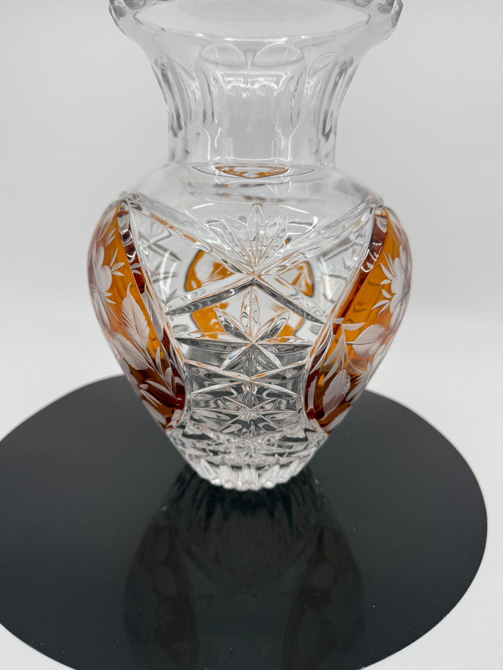 Amber crystal vase, close view on display stand showing floral panel (original color)