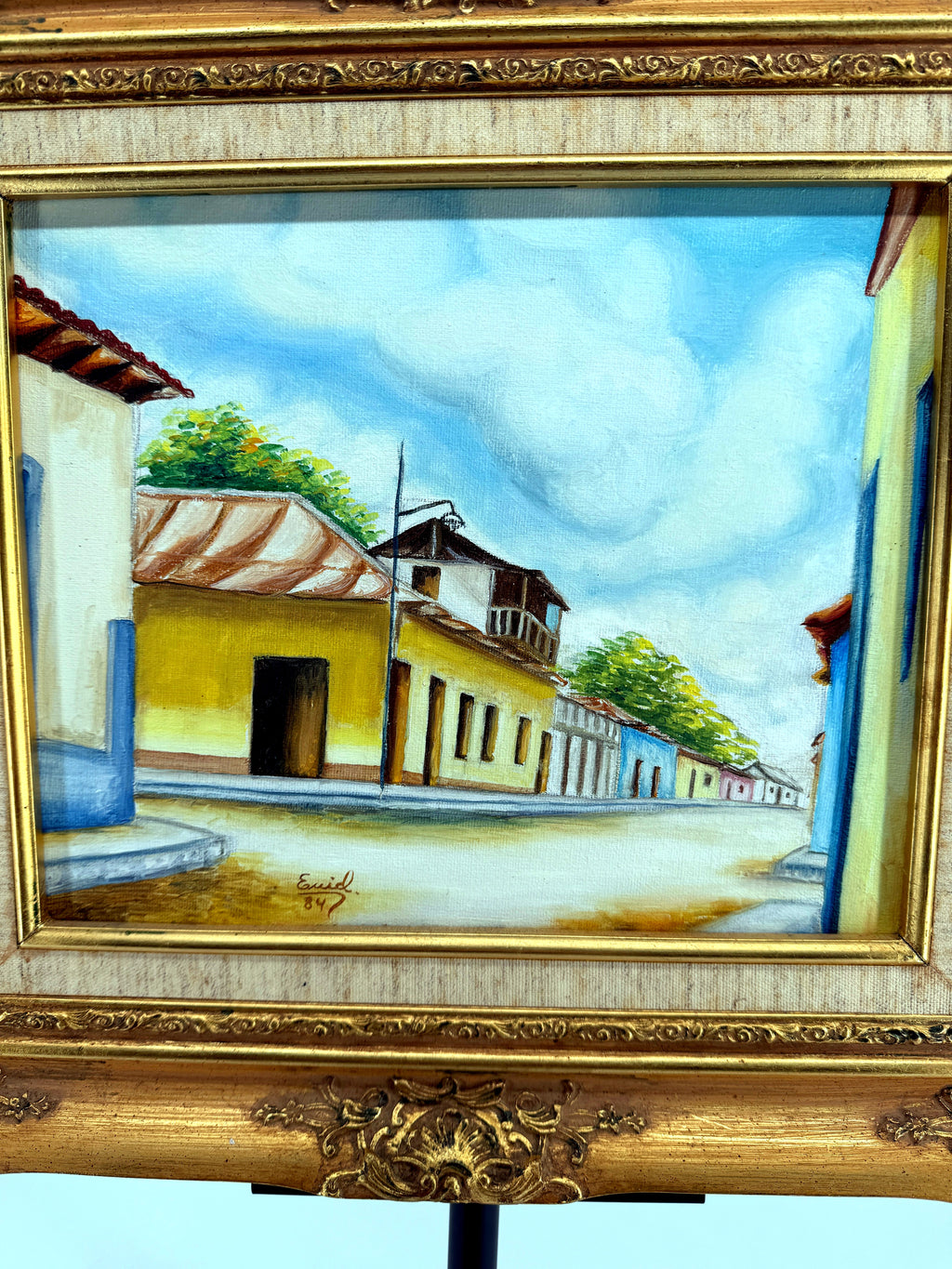 1984 signed oil on canvas Venezuelan street scene, framed — front view, close crop of the yellow colonial buildings