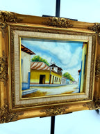 1984 signed oil on canvas Venezuelan street scene, framed — front view from a left angle