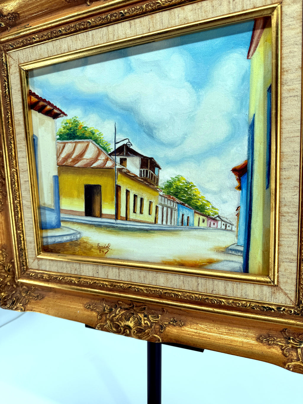 1984 signed oil on canvas Venezuelan street scene, framed — front view from a right angle