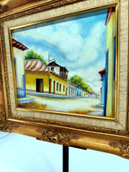 1984 signed oil on canvas Venezuelan street scene, framed — front view from a right angle