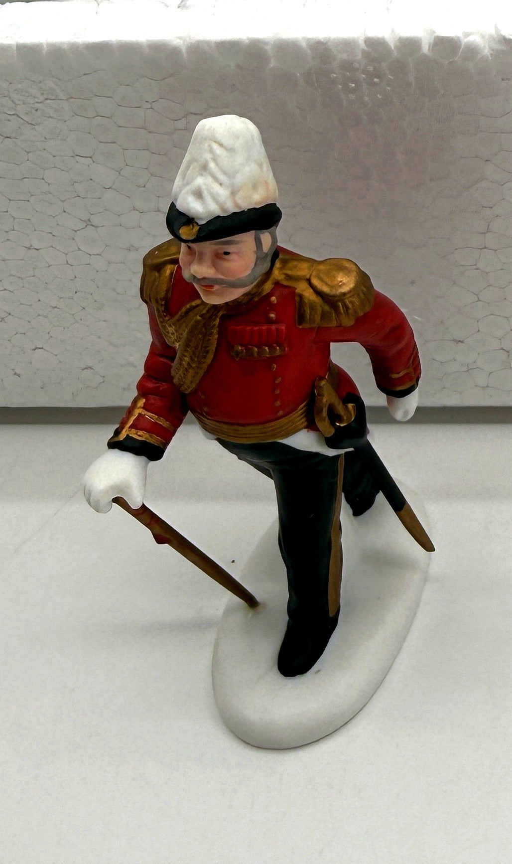 Close-up of the officer figurine - white plumed helmet, gold epaulettes, cane and sword
