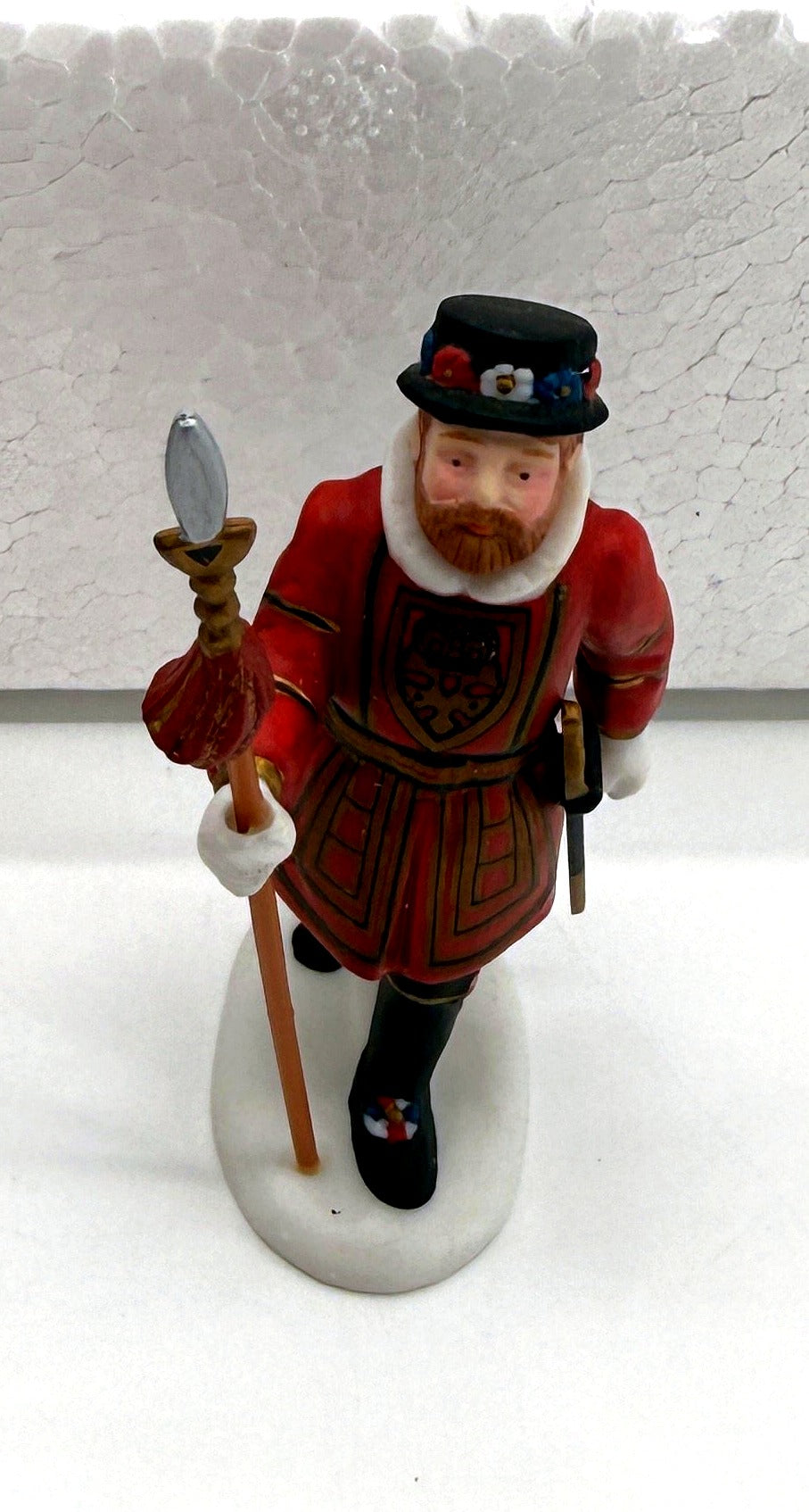 Close-up of a Beefeater guard figurine - Tudor rose tunic, white ruff collar and halberd